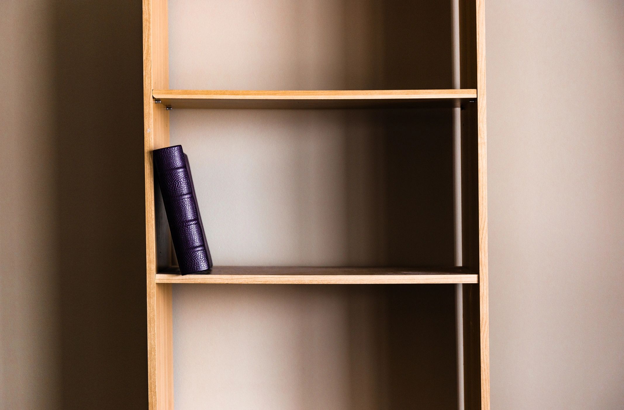 A single book on an empty shelf