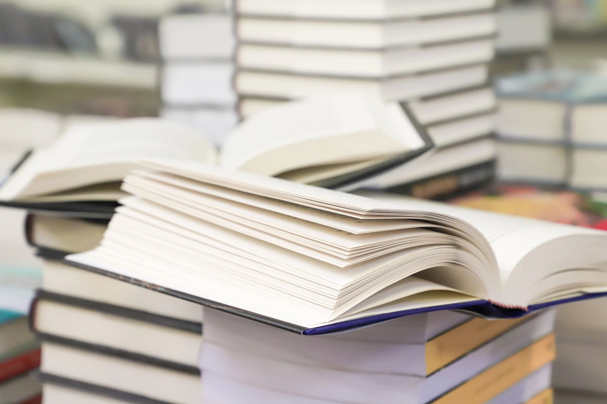 Stack of books with an open book on a table