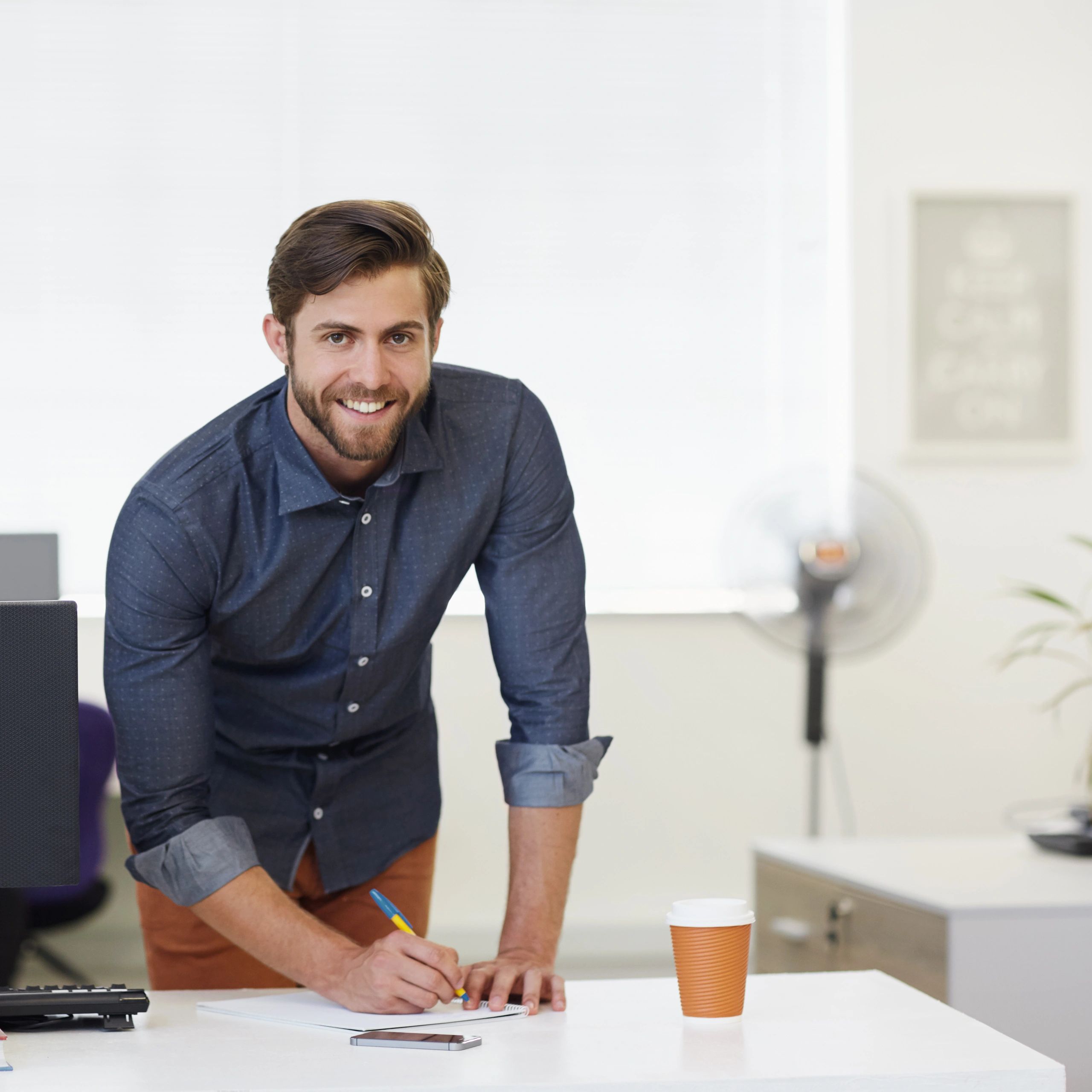 Portrait of a person writing notes at a desk